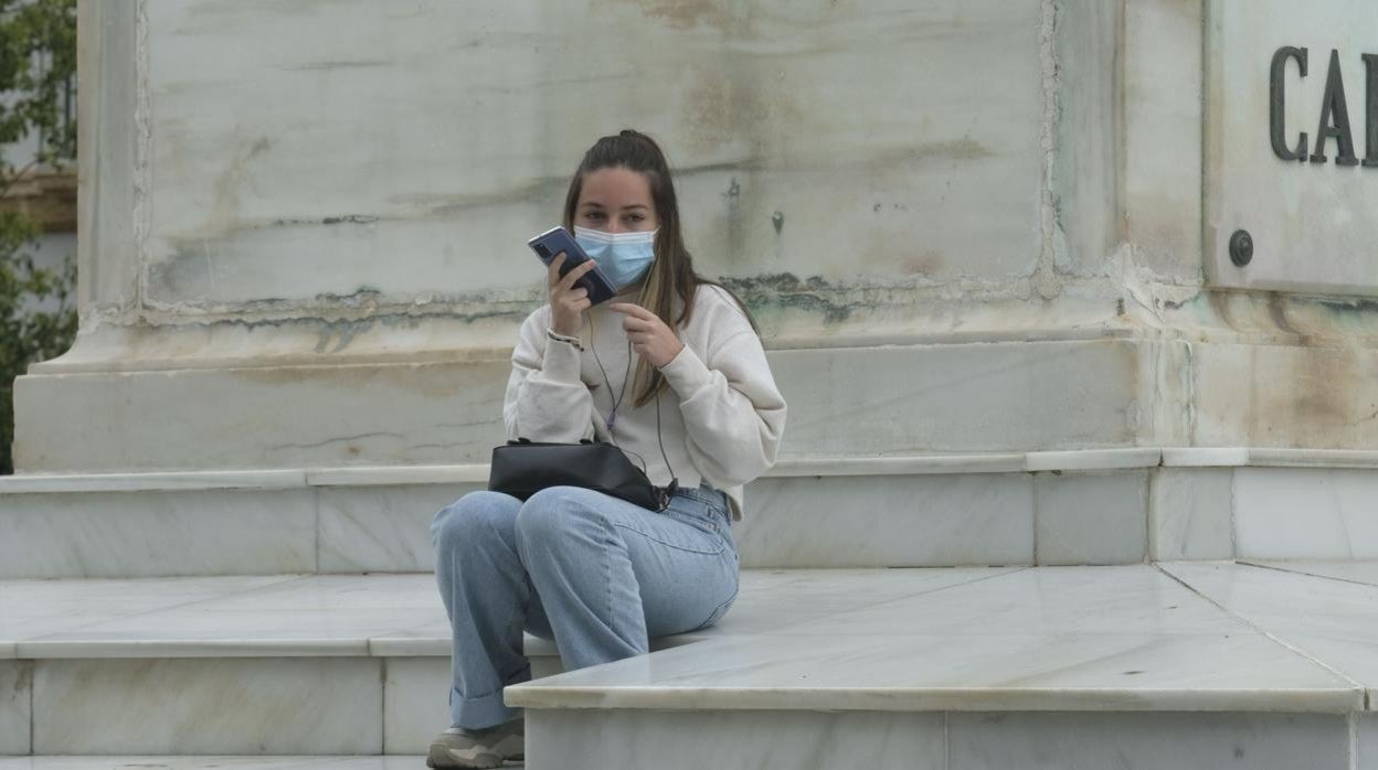 Una joven con mascarilla en la plaza de San Juan de Dios.