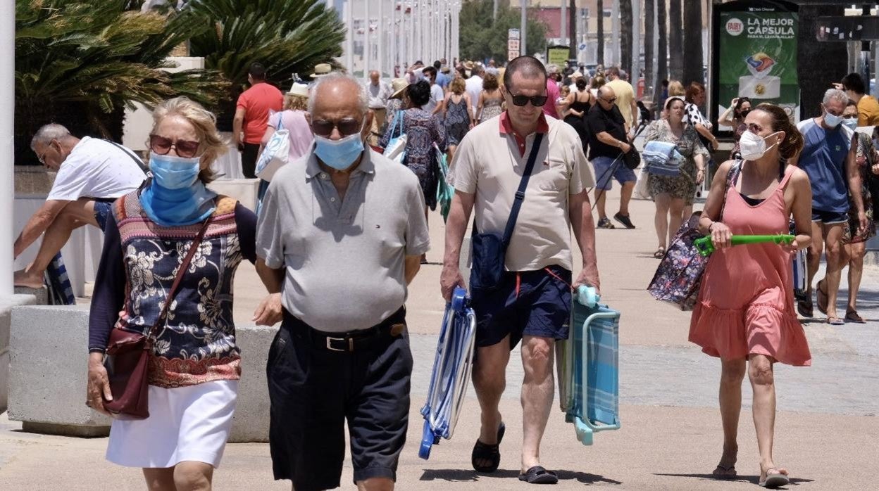 Personas con mascarilla en el Paseo Marítimo de Cádiz.