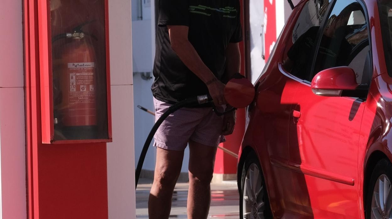 Un ciudadano suministrando carburante a su coche, mientras el precio de la energía se dispara.