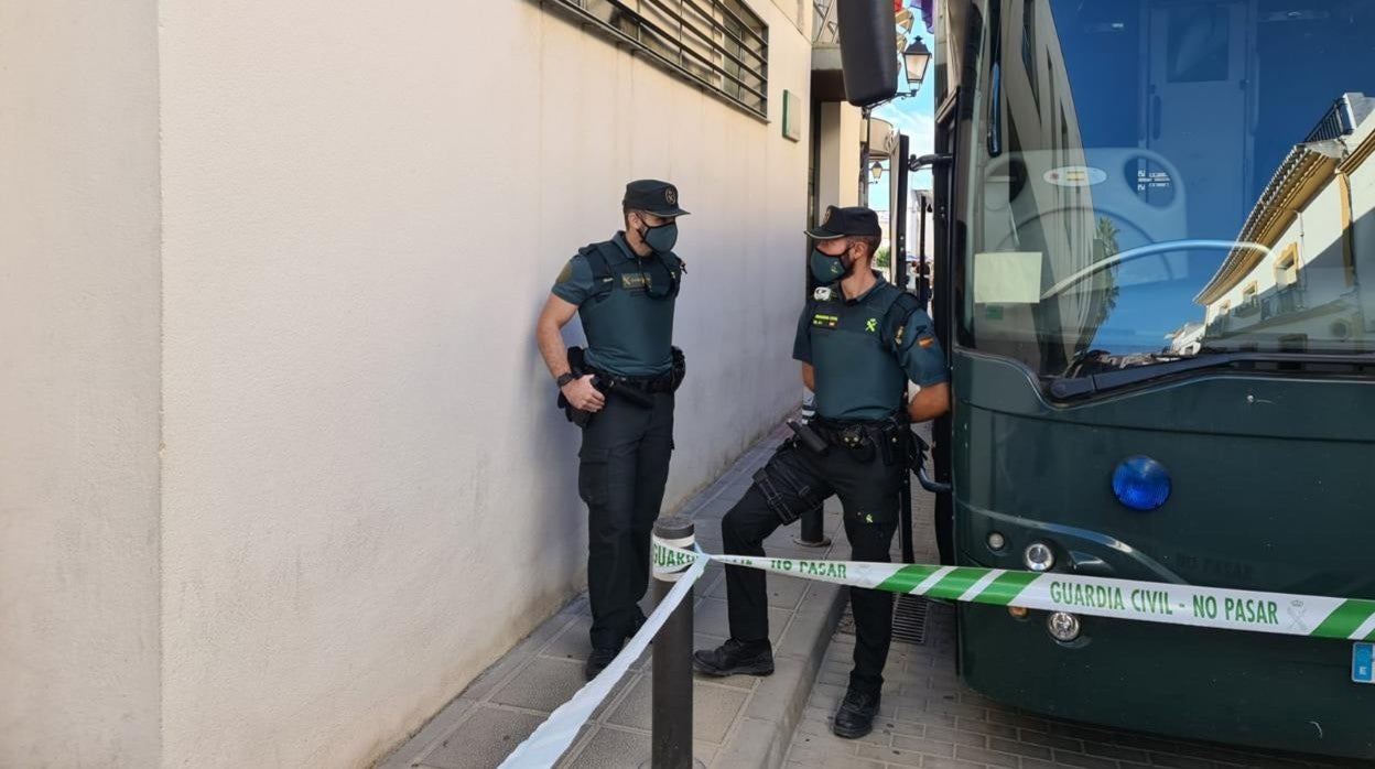 Dos agentes custodian el autobús en el que han trasladado a los detenidos al juzgado de Sanlúcar