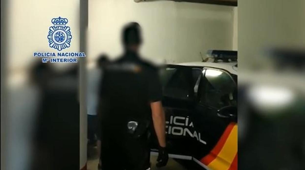 Los agentes introducen en un coche patrulla a uno de los nueve investigados por el crimen de Cayetano Romero