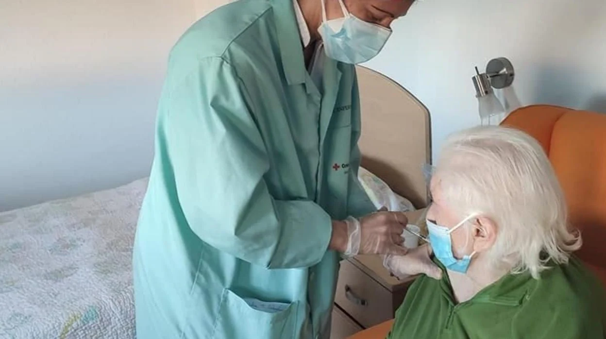 Una enfermera aplica la tercera dosis a una anciana en la residencia de mayores de la Cruz Roja de San Fernando.