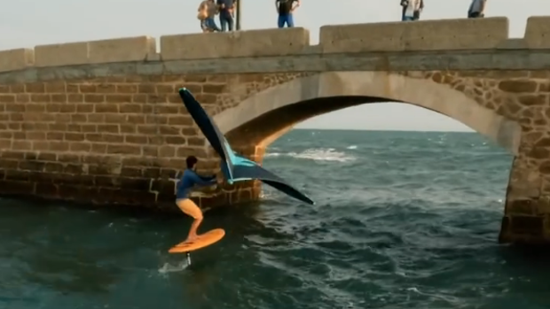 Antoine Auriol, excampeón mundial de kite surf,  pasa con su tabla por debajo del Puente Canal