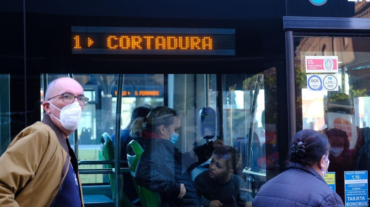 Usuarios del autobús urbano de Cádiz, con las mascarillas, ayer en una parada.