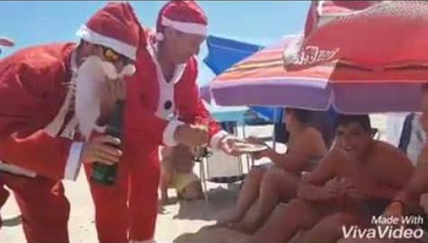 Papá Noel llega a pleno sol y a 40 grados a una playa de Huelva para repartir polvorones