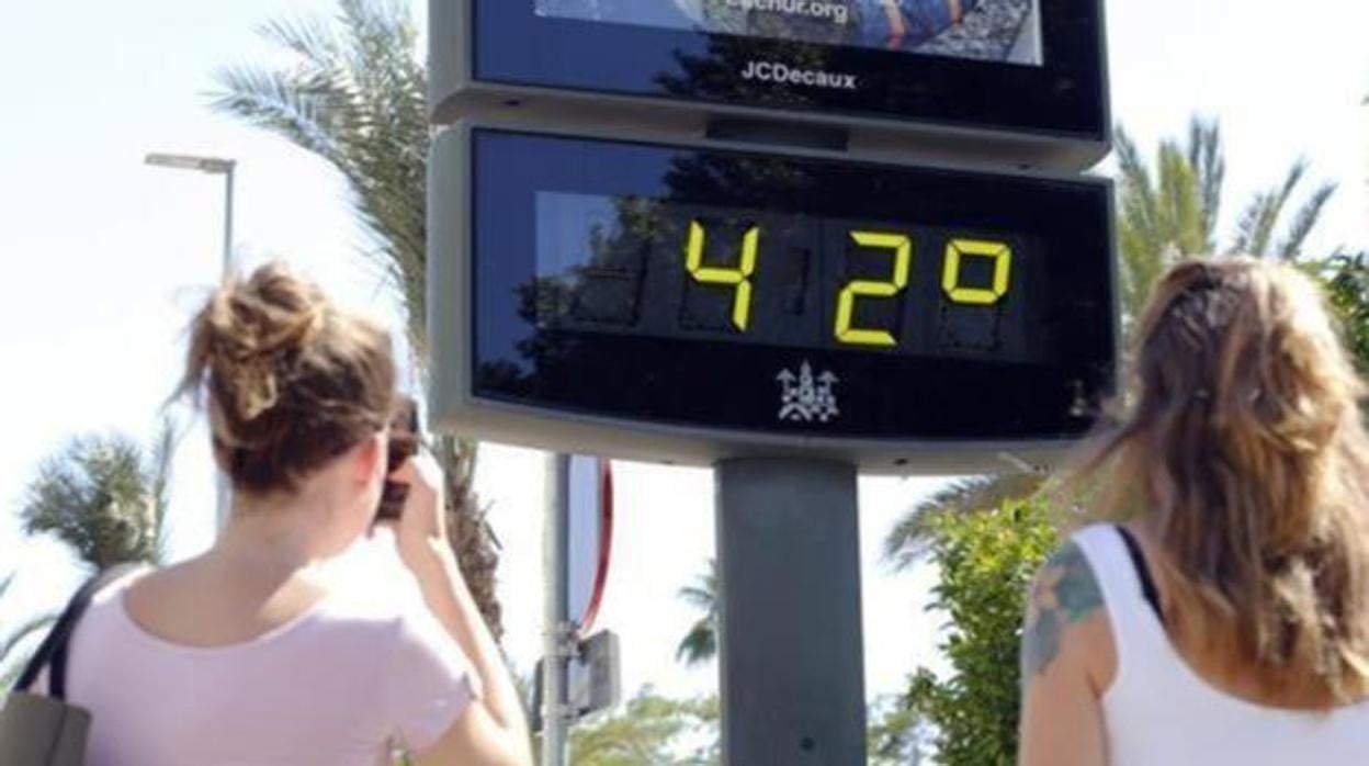 Dos personas observan un termómetro en ola de calor