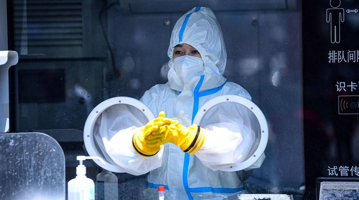 Un trabajador médico se prepara para realizar pruebas de ácido nucleico para el coronavirus Covid-19 en un sitio de recolección de hisopos en Shenyang, en la provincia nororiental china de Liaoning, el 25 de mayo de 2022 China OUT AFP