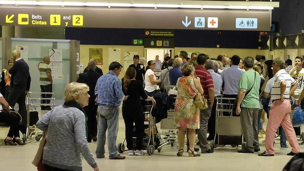 Decenas de pasajeros esperan colas en el aeropuerto de Sevilla