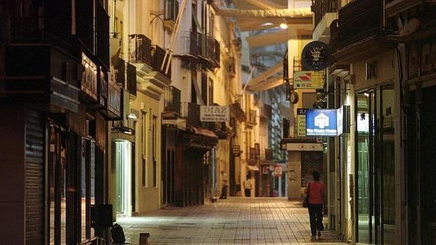 Una chica camina sola por una calle de Sevilla