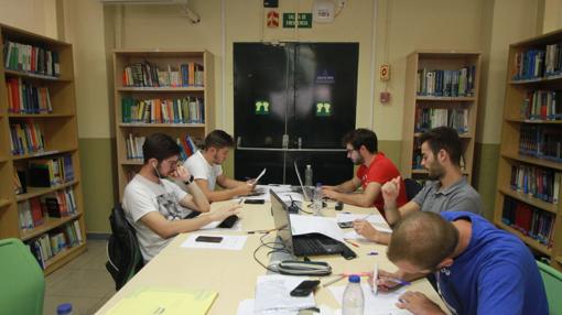 Salida de emergencia de la biblioteca de la Politécnica taponada por una mesa con seis puestos de estudio