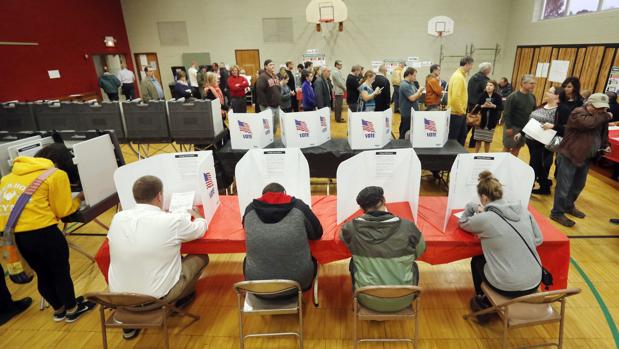 Votantes estadounidenses rellenan sus papeletas en un colegio electoral de Ohio