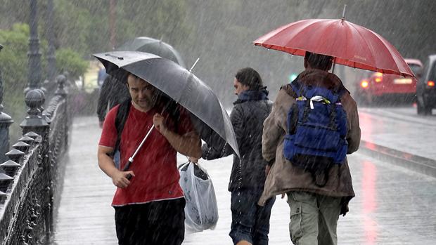 Un joven se resguarda de la lluvia con su paraguas