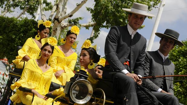 Un grupo de jóvenes disfrutan de un paseo en coche de caballos por el Real