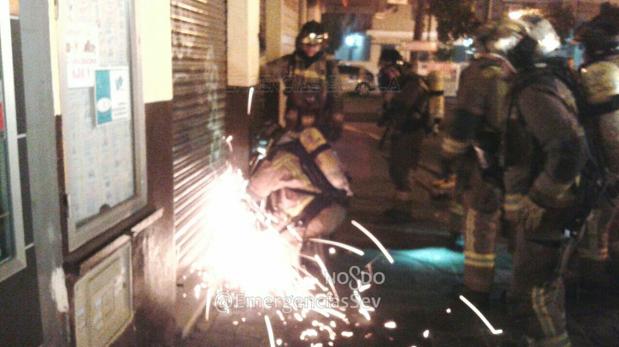 Los Bomberos de Sevilla accedieron a través del cierre metálico de la confitería