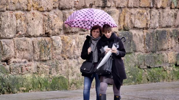 Dos mujeres de protegen de la lluvia en Sevilla