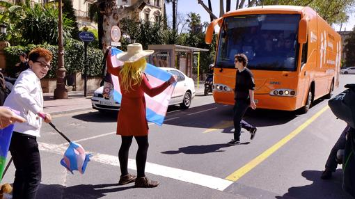 F. A., responsable de prensa de Podemos Andalucía, ante el autobús de Hazte Oír