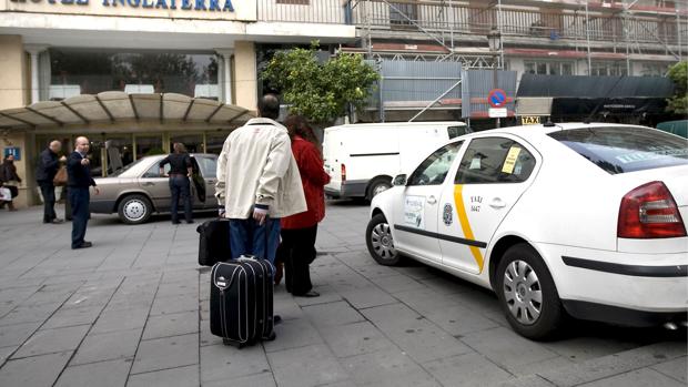 Turistas cogen un taxi en el hotel Inglaterra