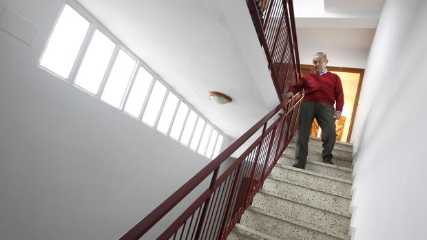 Un anciano baja las escaleras de su bloque que carece de ascensor