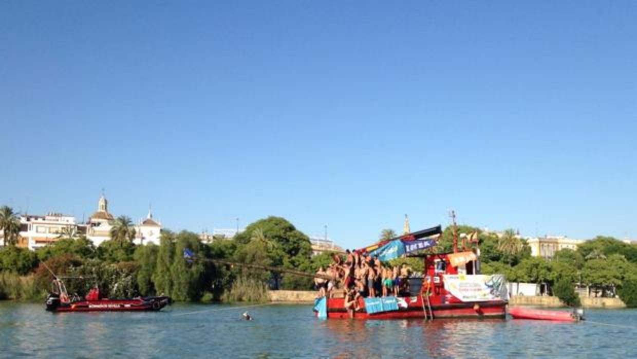 Jóvenes durante la tradicional cucaña de la Velá de Santa Ana