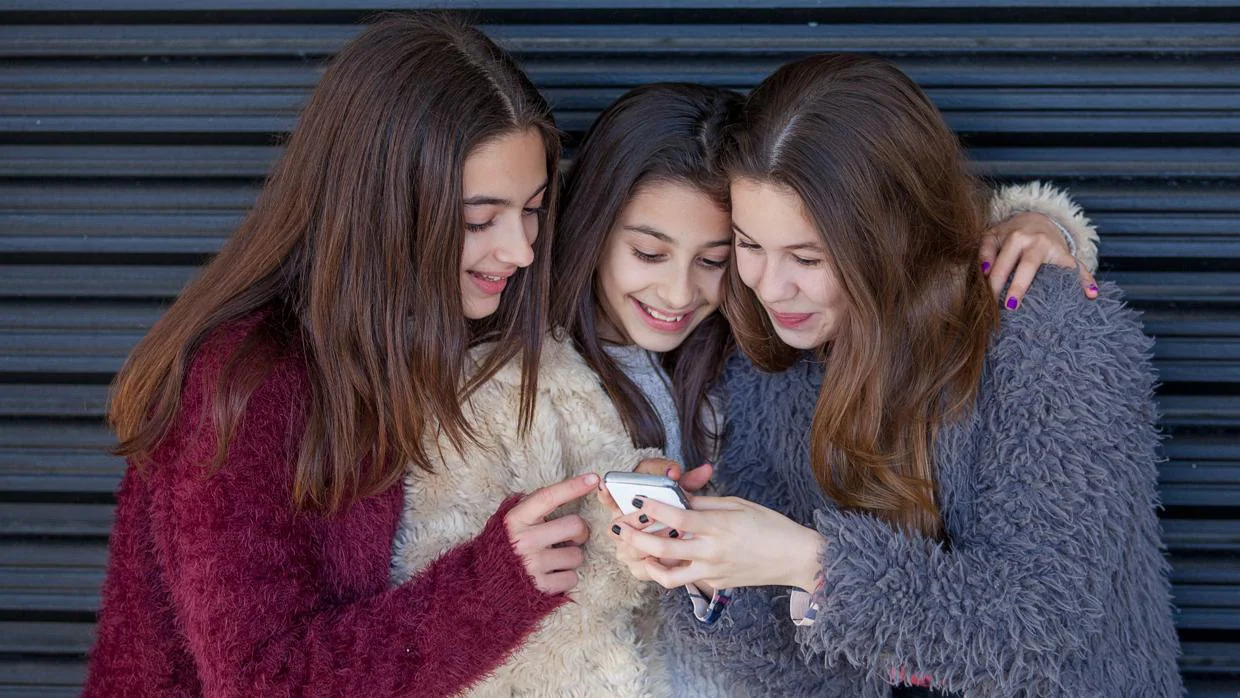 Un grupo de niñas mira el móvil