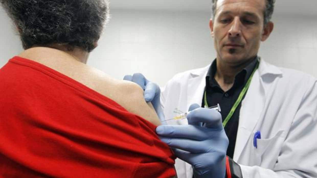 Una mujer se vacuna de la gripe en un centro de salud