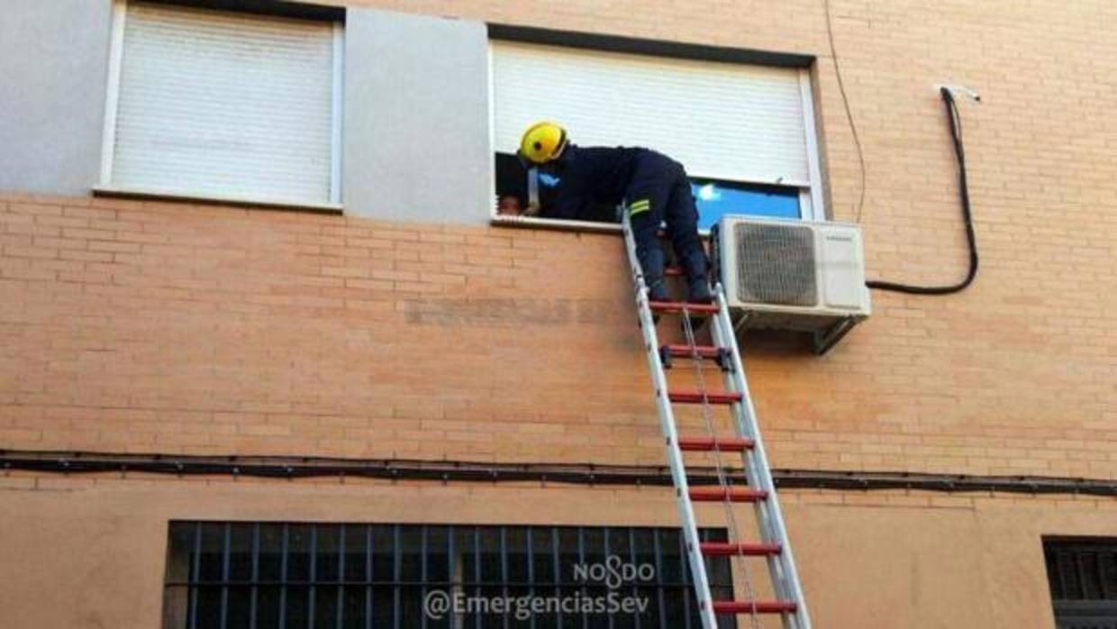 Los bomberos accediendo a la vivienda para rescatar al niño