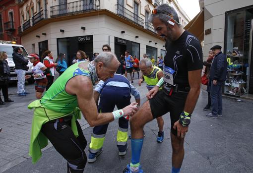 Un corredor auxilia a otro en la Zurich Maratón de Sevilla de 2017