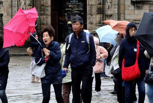 Turistas japoneses luchan por no perder sus paraguas