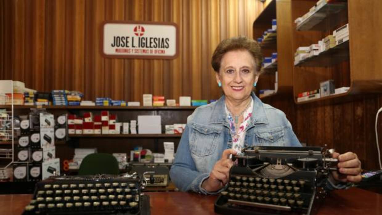 Josefina Sánchez Montoya, en el mostrador de su tienda, entre algunas máquinas de escribir antiguas