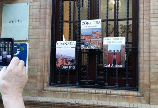 Anuncio de la venta de entradas para el Alcázar evitando la cola, en una tienda cercana al monumento