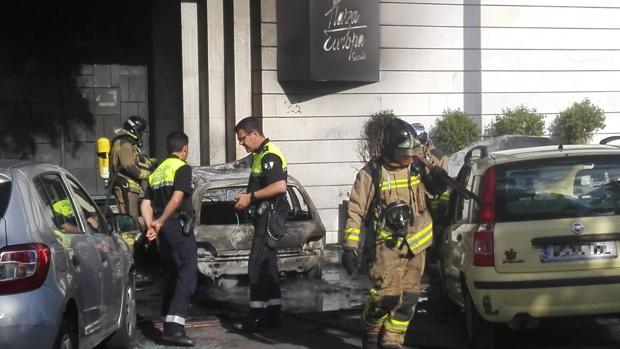 Unos encapuchados empotran y queman un coche en la puerta de una discoteca en la Cartuja en Sevilla