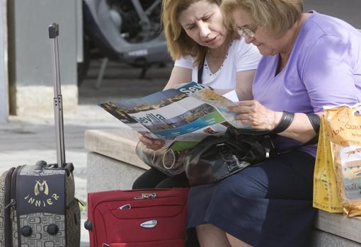 Dos visitantes se ubican en el plano de la ciudad