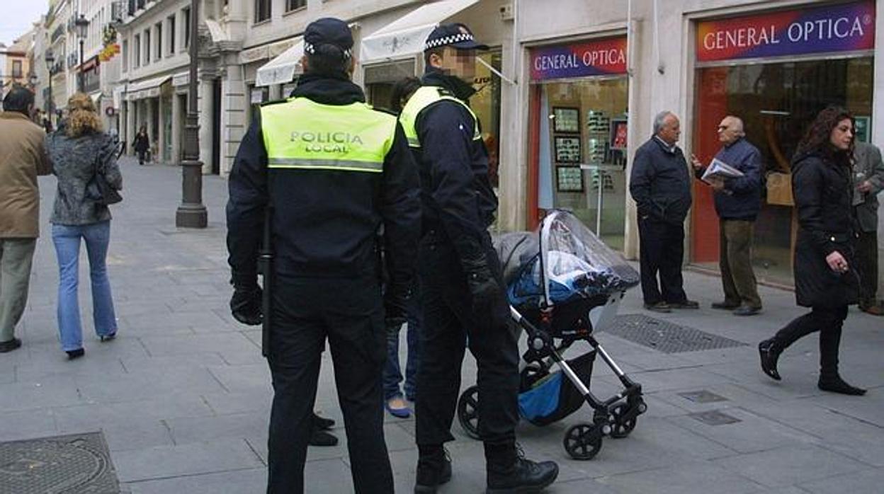 Policía locales de servicio en una calle comercial del centro