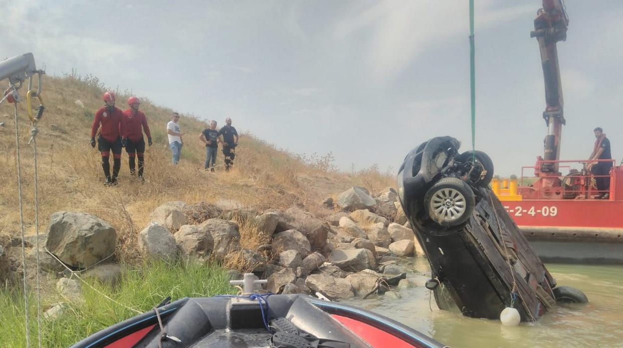 Los bomberos trabajan en sacar el vehículo del río