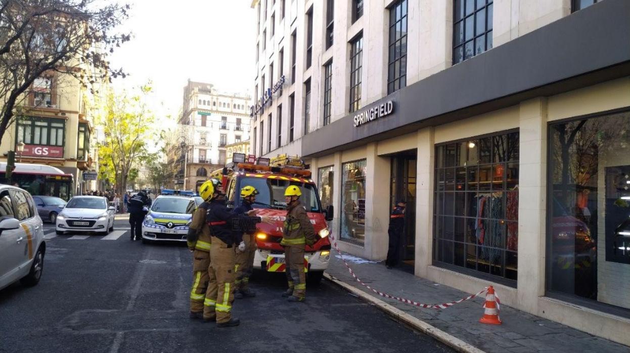 Los bomberos y la policía acotan la zona tras la caída del cartel