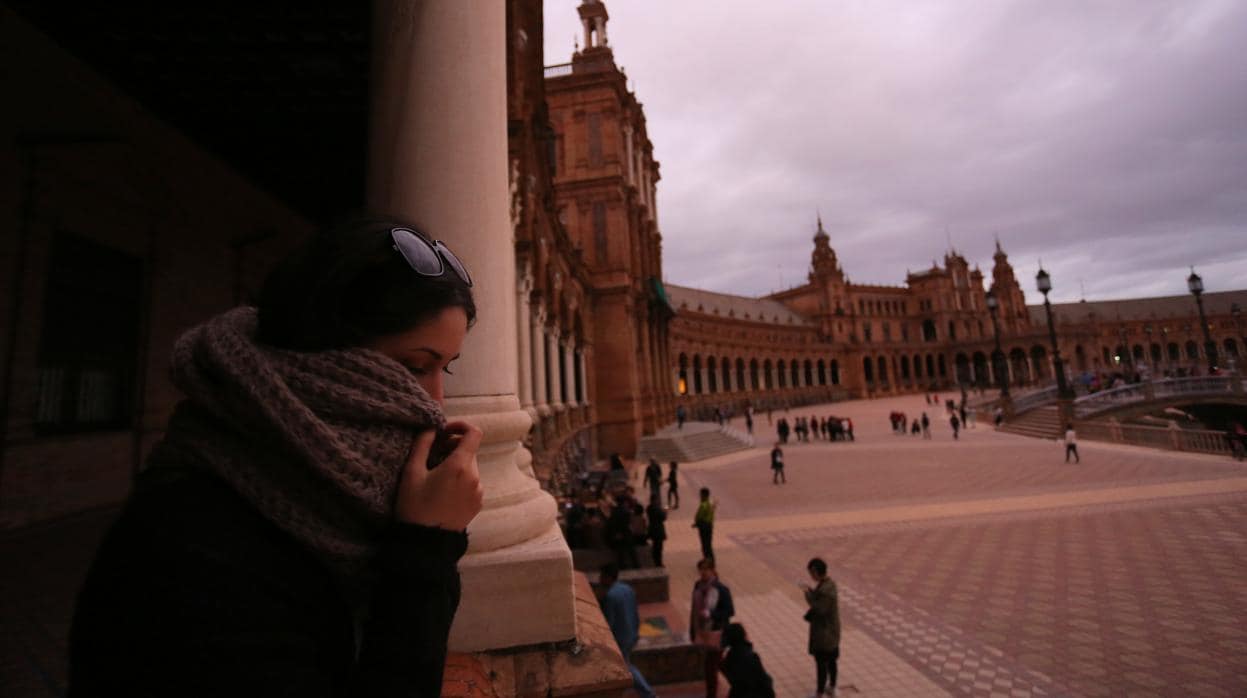 Una joven pasea con frío por la plaza de España de Sevilla