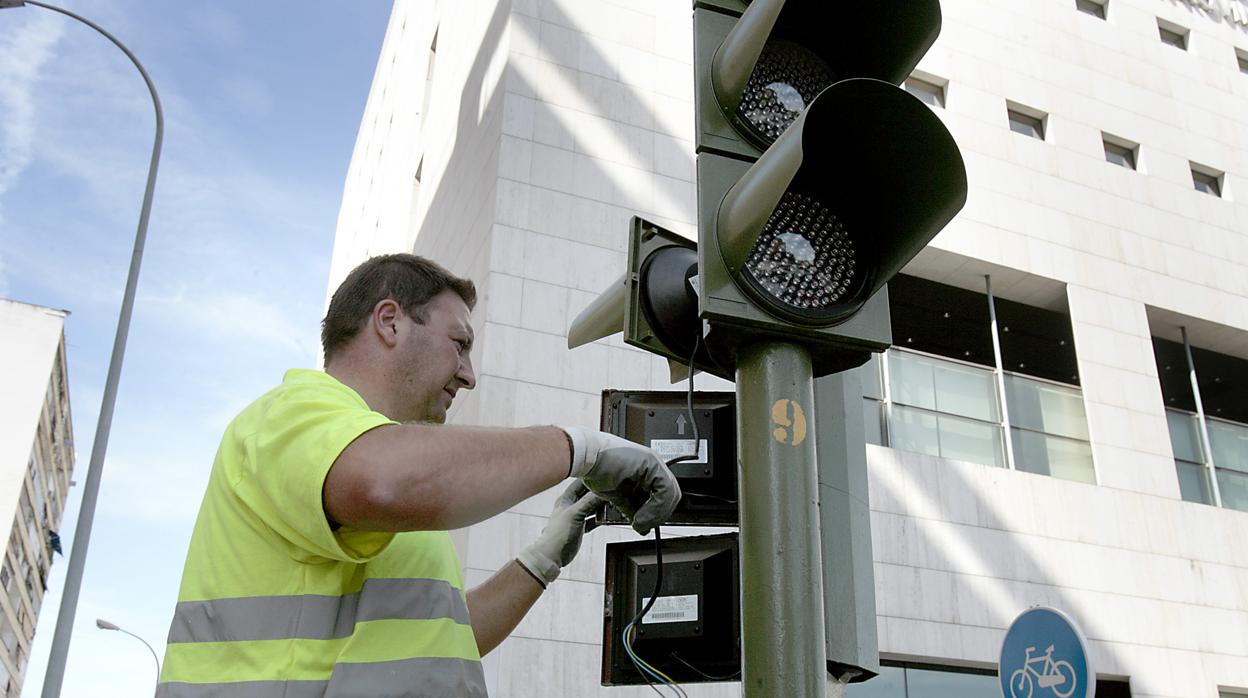Un operario municipal, reparando un semáforo de Sevilla