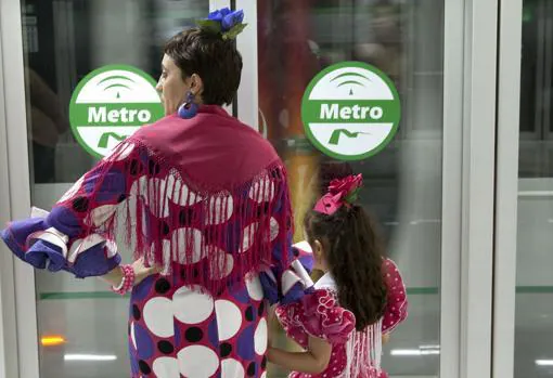 Madre e hija vestidas de flamenca esperando el metro