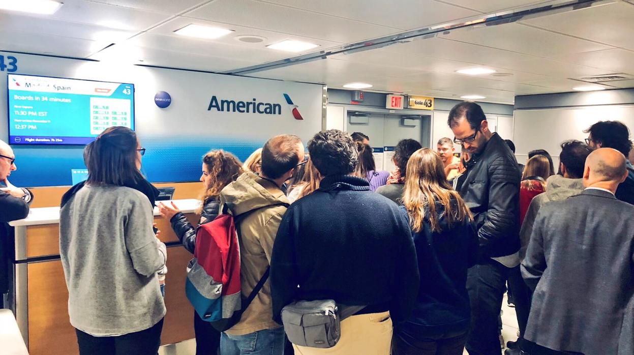 Pasajeros afectados por el retraso ante el mostrador de American Airlines