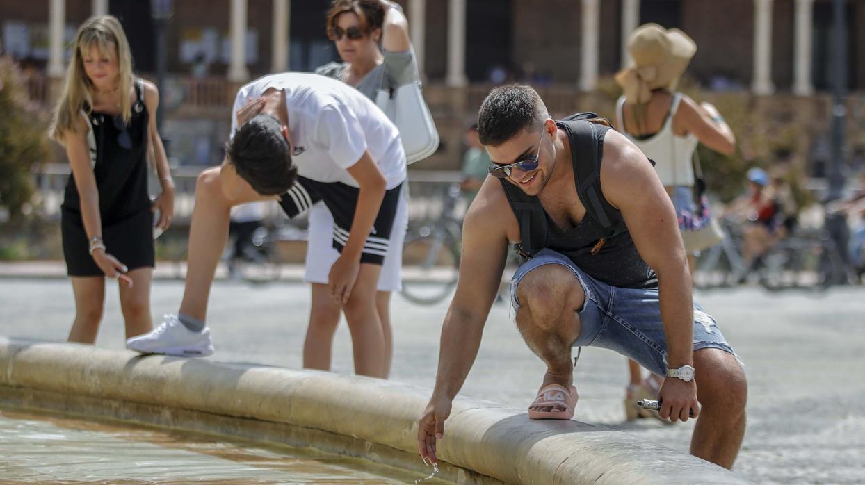 Turistas refrescándose en la fuente de la Plaza de España