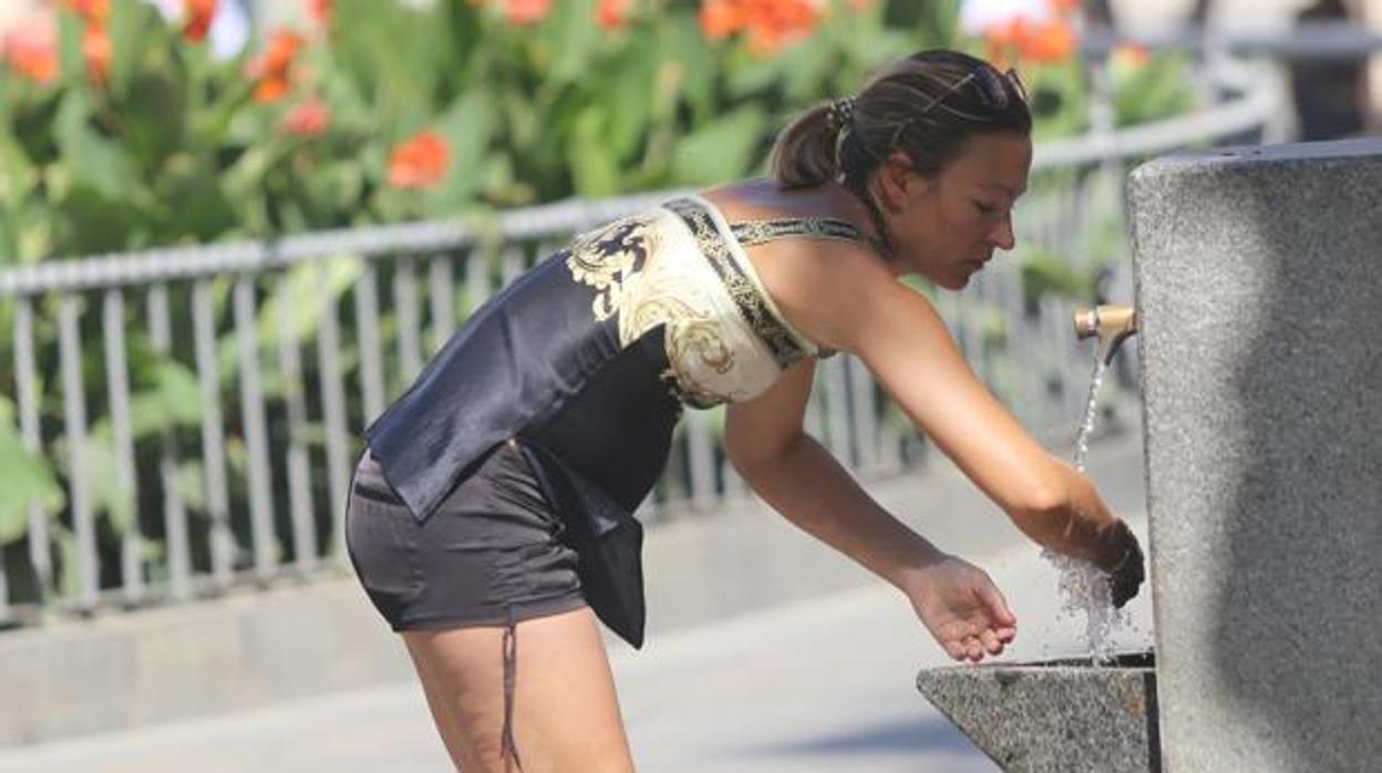 Mujer refrescándose en una fuente