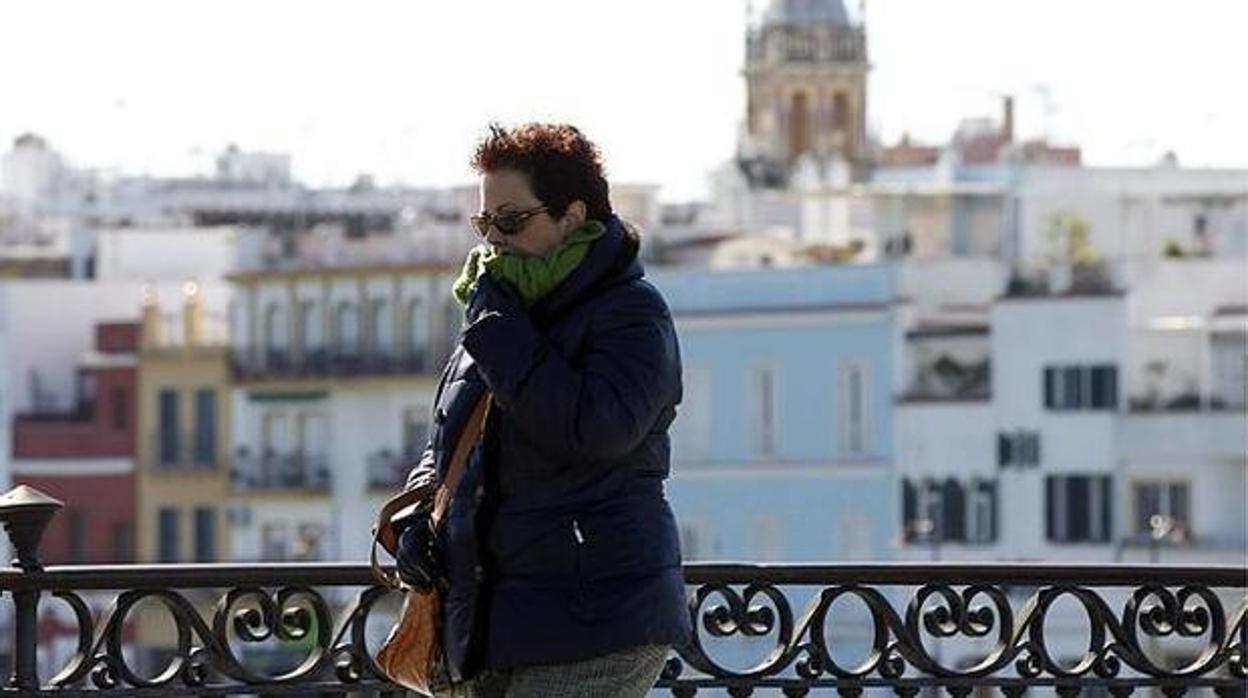 Una mujer abrigada en el Puente de Triana