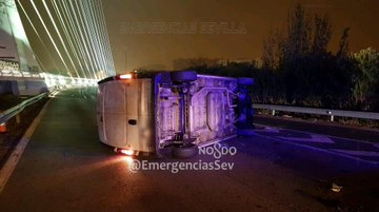 La furgoneta accidentada, en medio de la vía de acceso al puente del Alamillo