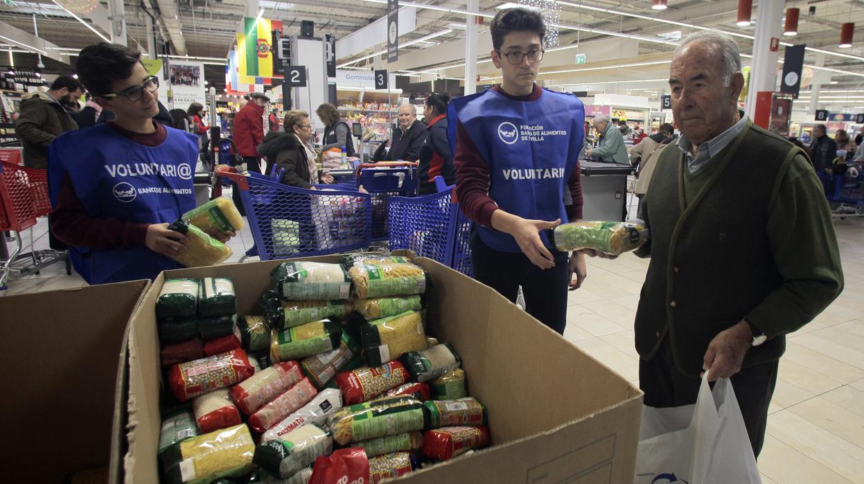 Voluntarios recogiendo alimentos en un supermercado de Sevilla