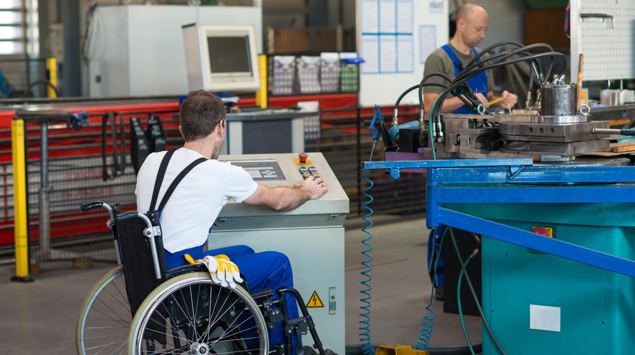 Un trabajador en silla de ruedas realiza el trabajo para el que fue contratado en una fábrica