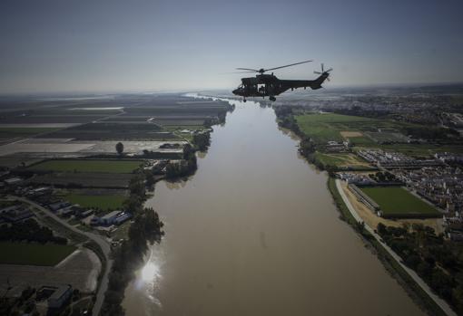 Un helicóptero del Bhelma IV sobrevuela el río por donde iría el puente