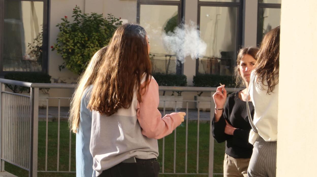 Unas chicas fuman en uno de los patios de Derecho