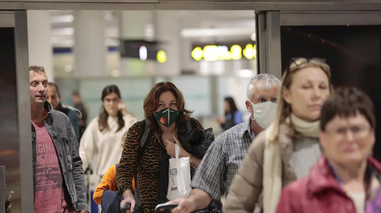 Pasajeros regresan con mascarilla al aeropuerto de Sevilla