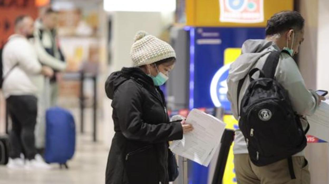 Dos turistas con mascarilla en el aeropuerto de Sevilla