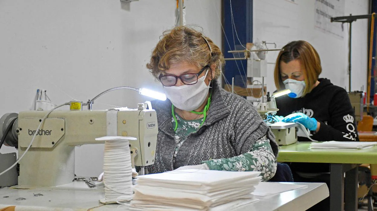 Mujeres confeccionando mascarillas en un taller de costura de Segovia